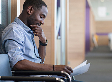 Man sat outside of meeting room going over notes